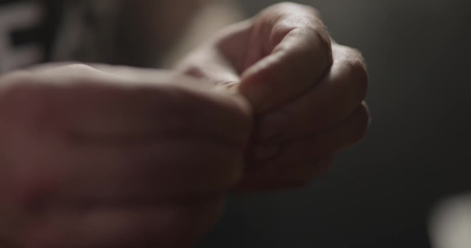 A man selects a single coffee bean from his hand and breaks it apart to taste