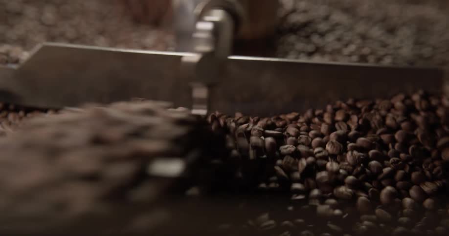 The beans are being roasted by a machine in the bin