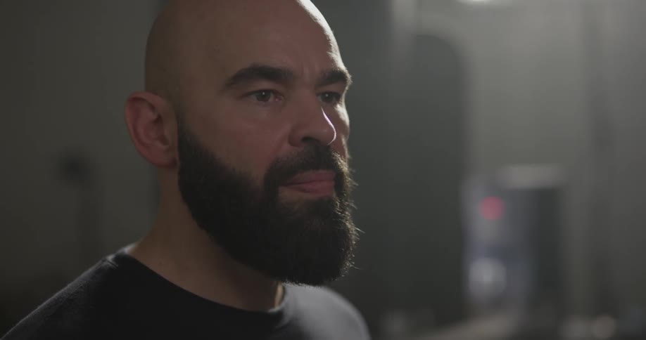 Bearded man puts something in his mouth and chews it