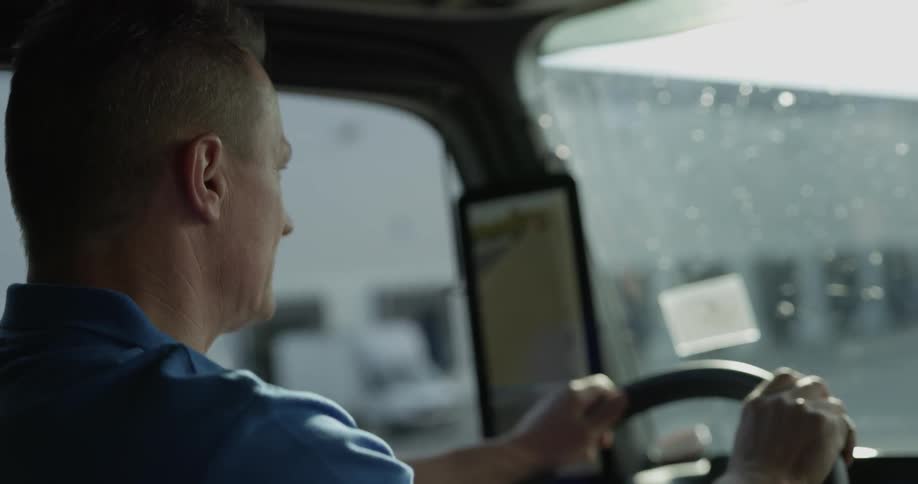 A man driving a truck across a loading dock