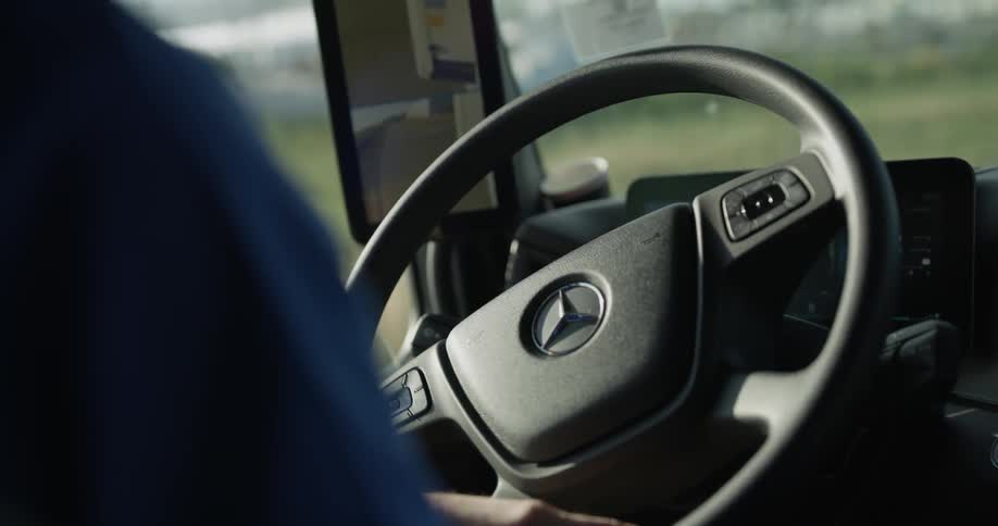 A man rotates the steering wheel of a mercedes vehicle