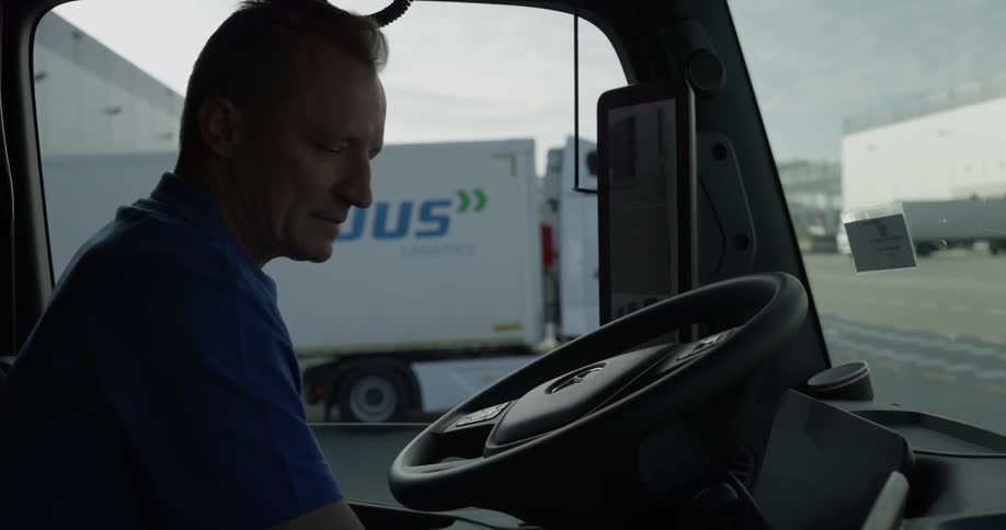 Man enters the cab of a truck and begins to drive away