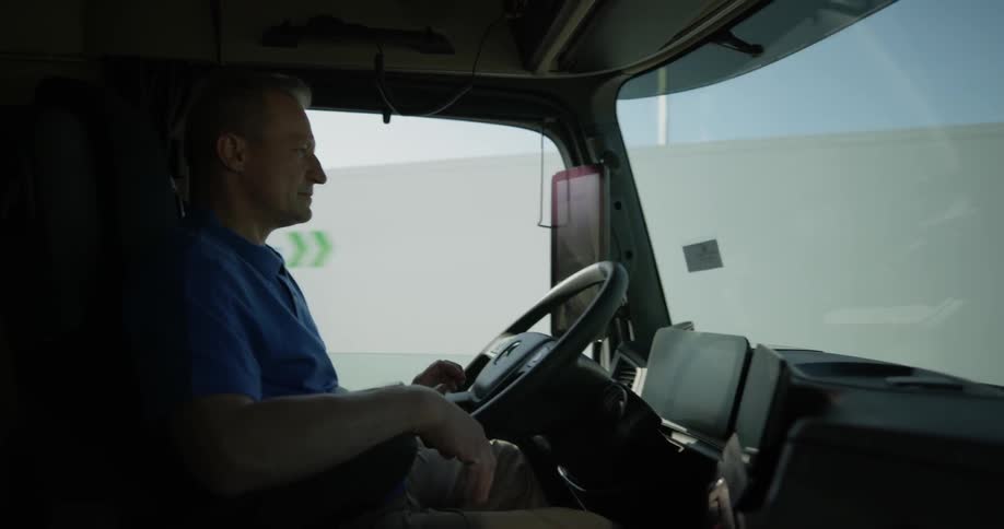 A man is driving a truck on a sunny day