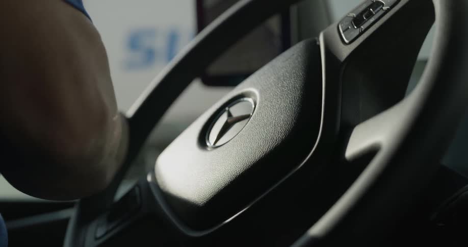 Male hands turning car steering wheel to the left