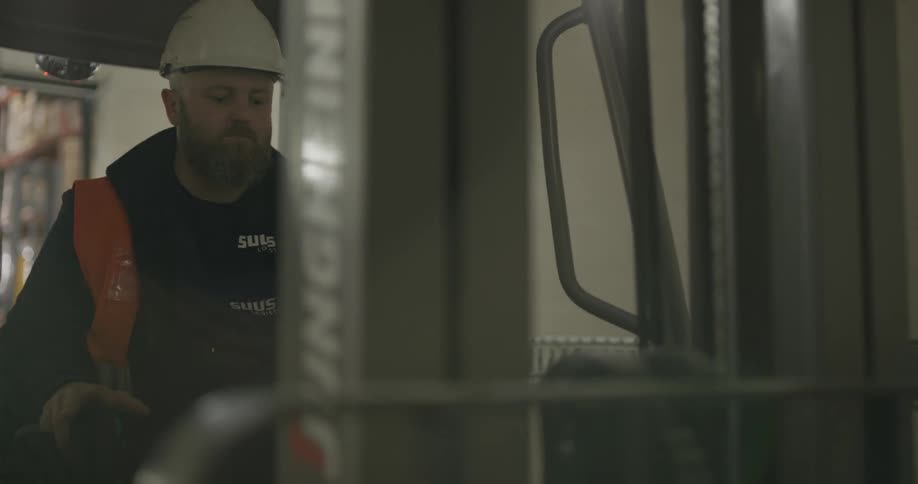 A man sitting and operating a forklift
