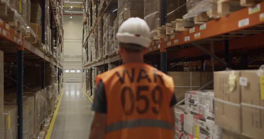 A male worker walks on the warehouse isle