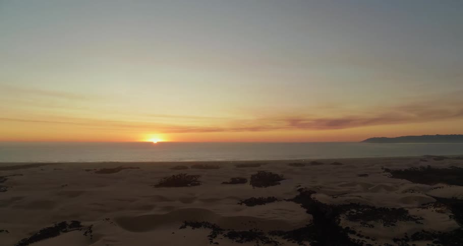 Aerial view of coastal area with calm seas at sunset