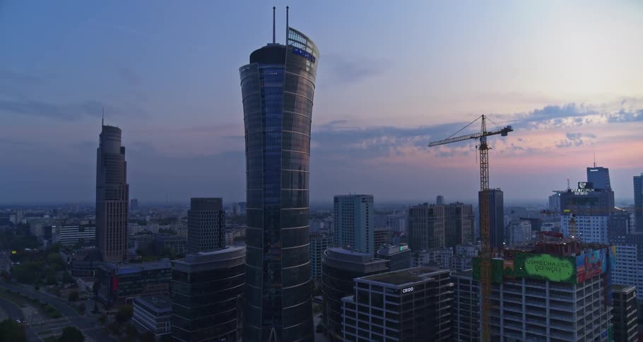 A tall skyscraper looms over the rest of the buildings in a city