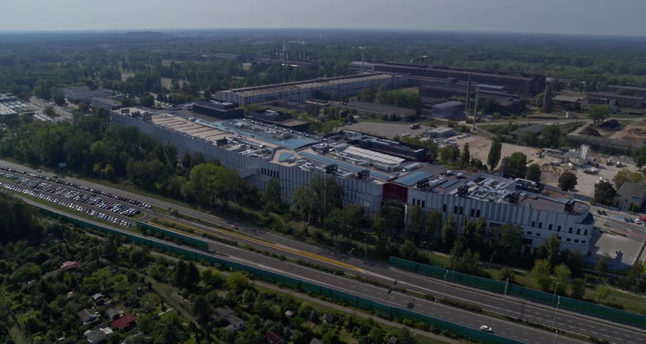 Rooftops of buildings and tree tops as cars travel in both directions on a highway
