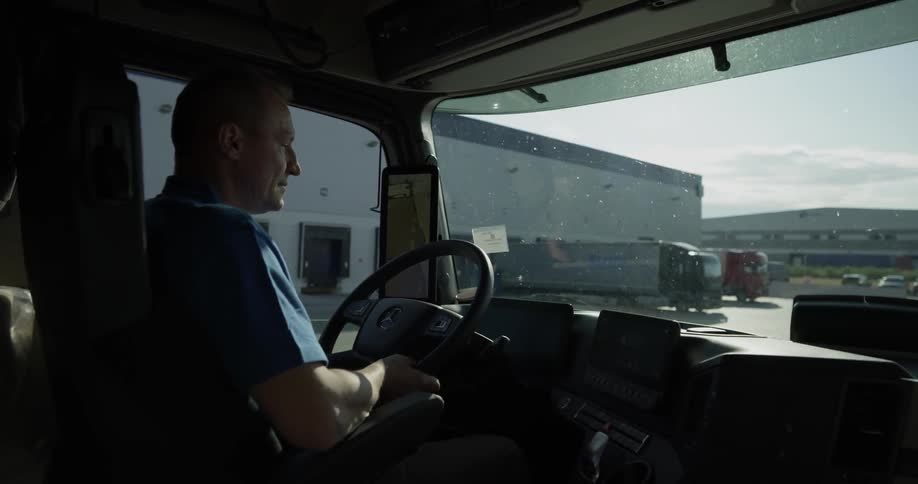A man driving a truck in the daytime