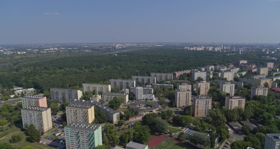 The apartment buildings line the forest ahead