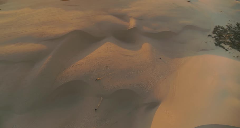 Motorcycles driving on desert sand dunes