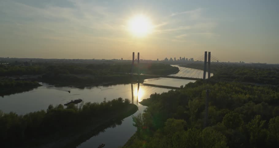 A bridge over a river with a city in the background