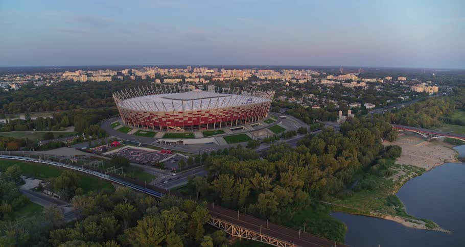 A sports arena on the edge of a river by a large city
