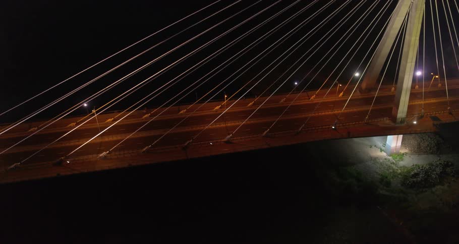 A suspension bridge with four lanes during the night