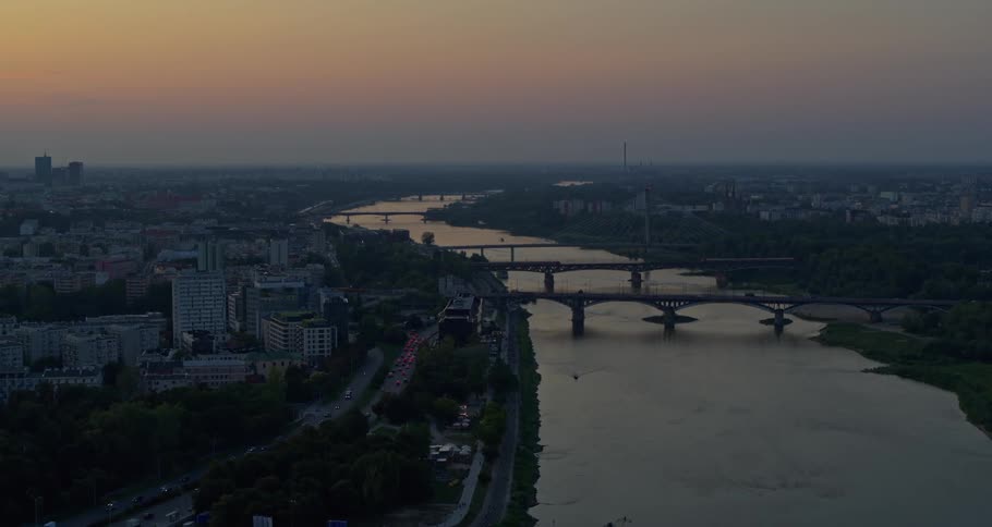 Bridges stretch across a winding waterway connecting cities at sunset