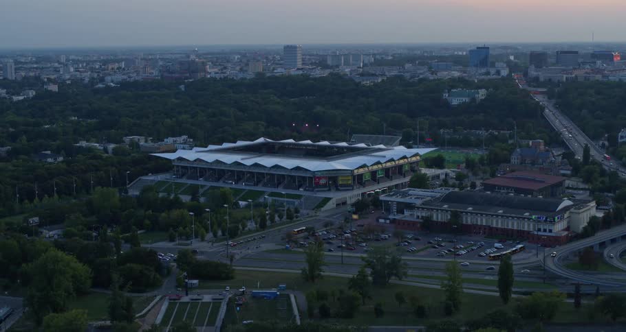 A road with a parking lot and a stadium in the background