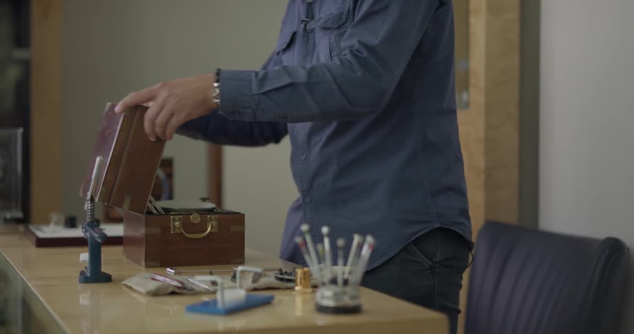 A man walks over to his desk and puts a box down