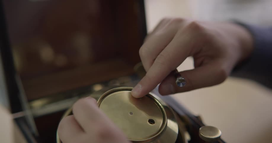 A person is putting a screw in a clock
