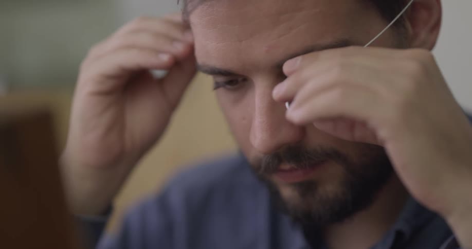 A man uses an eye magnifying glass after he opens a box