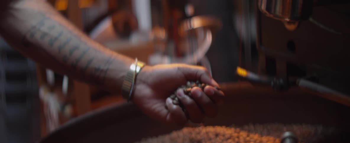 A man picking up a handful of beans