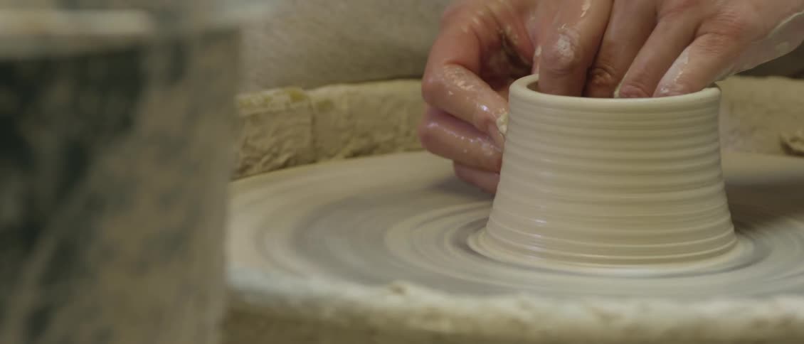 Person using a pottery wheel to make a sculpture