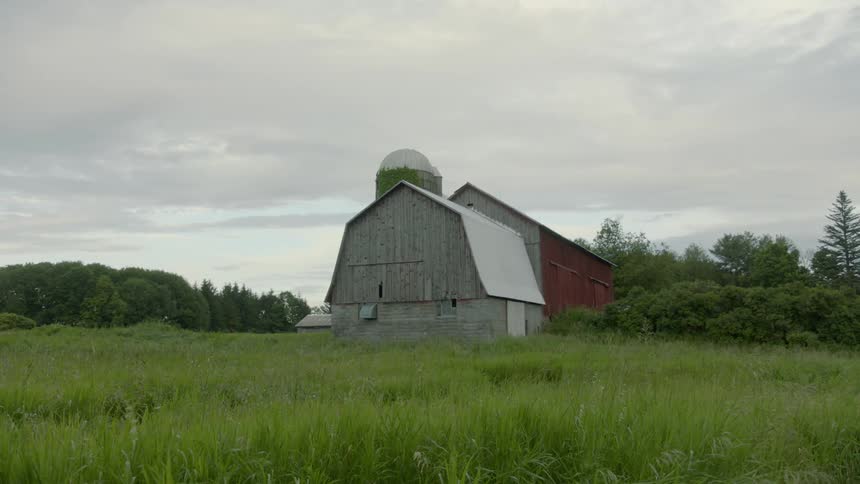 The barn sits by the tall grass