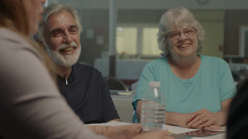 People sitting around a conference table laugh and talk