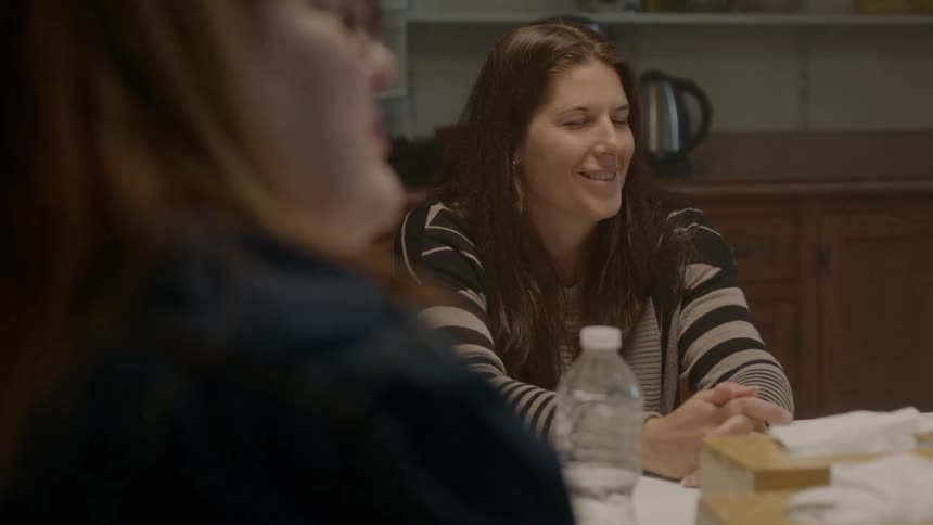 Women sit at a table talking and laughing