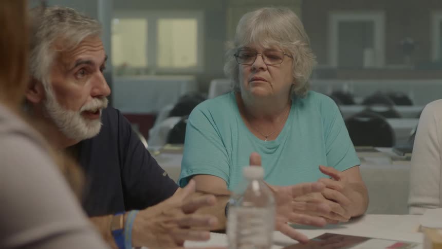 People sit in the dining room together with a man talking