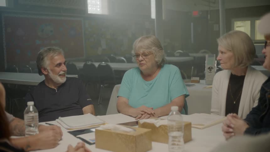 People sitting at the table have a conversation indoors during daylight