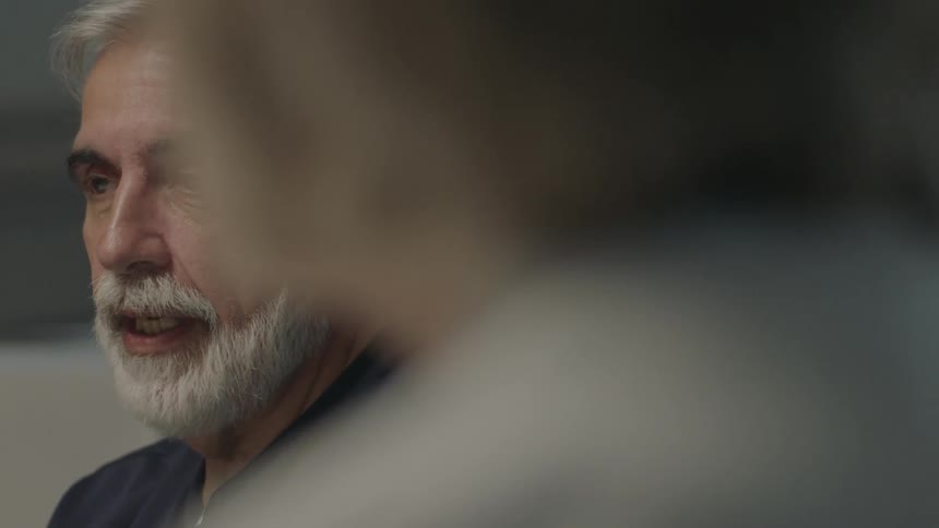 A man is talking with others in the room