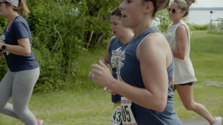 Female runners running in a 5k run near a lake