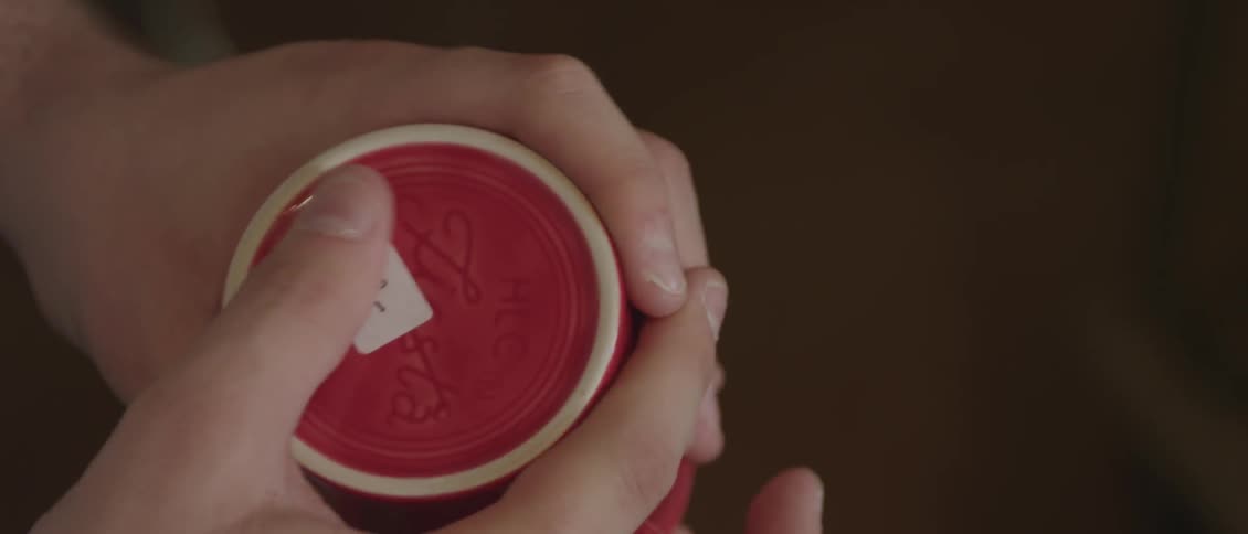 A person smooths a price tag onto a mug