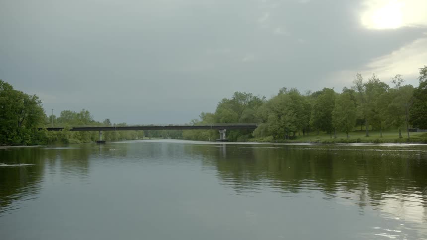 A calm river flows under a bridge