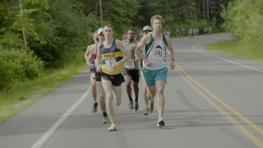 A long trail of men running a marathon down a road