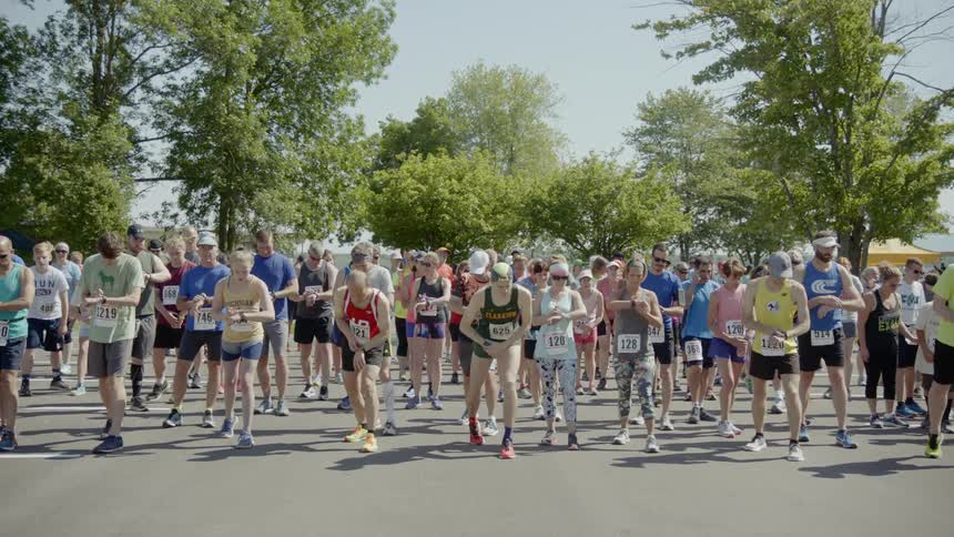 A race starting line with dozens of people waiting to run
