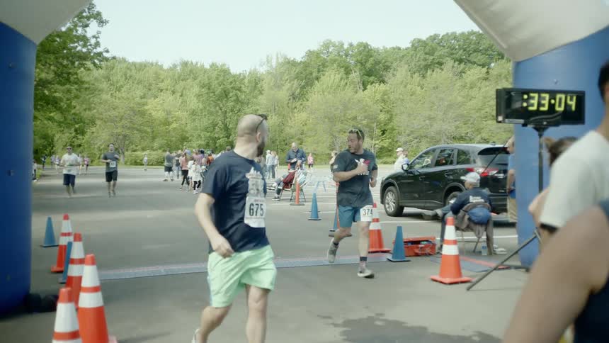 People run across the finish line at a race