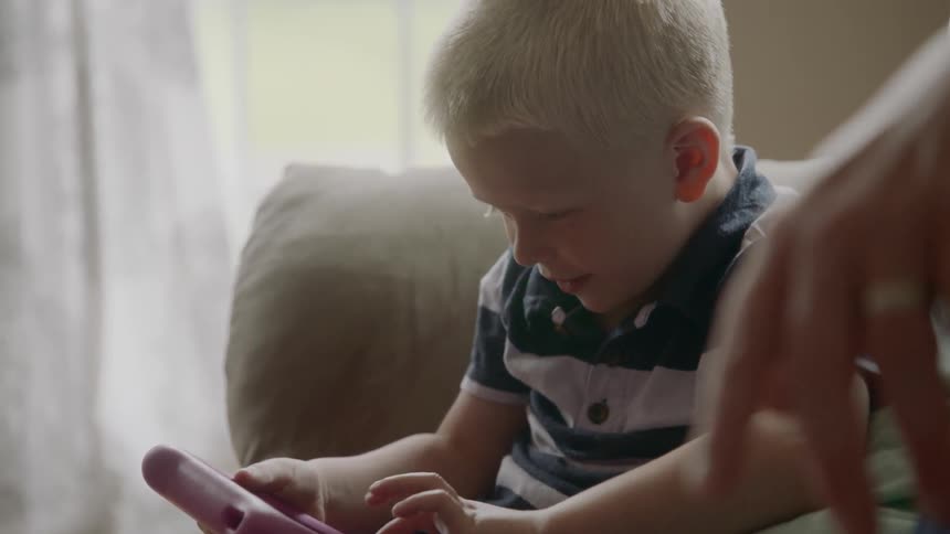 A young boy plays with a handheld toy
