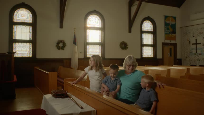 Grandma and grandkids sitting in a church pew