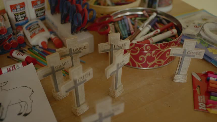 The table is full of art supplies and crosses