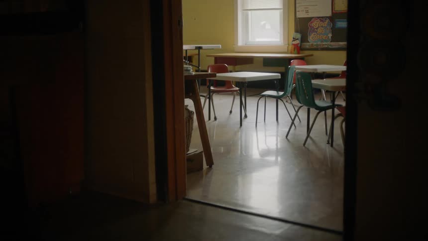 Desks sit in an empty school classroom