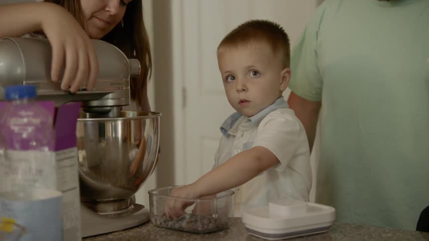 A man and woman bake in the kitchen with their kids