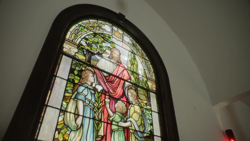 Close up of a stained glass window with jesus on it