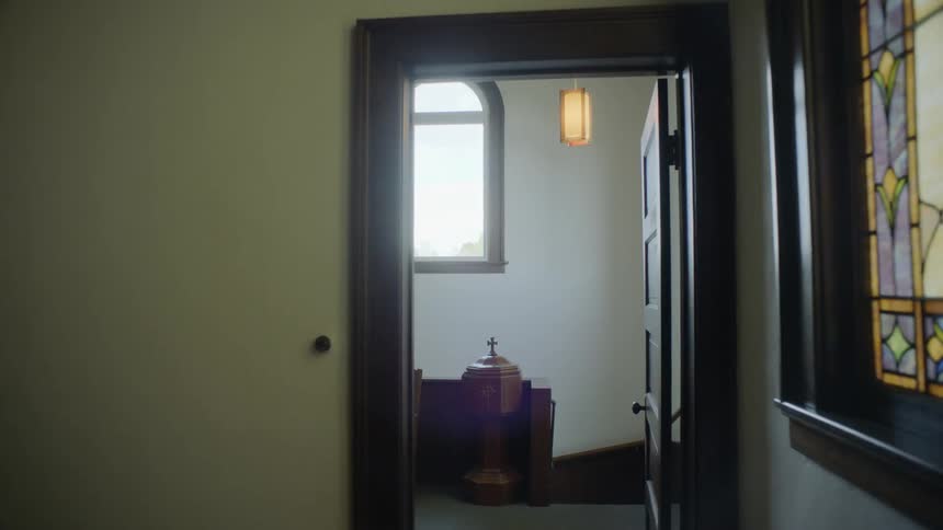 A hallway in a church with a ceiling light turning on and off