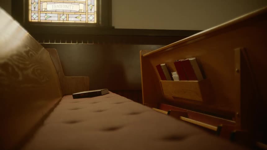 An empty church pew with bibles on the pew