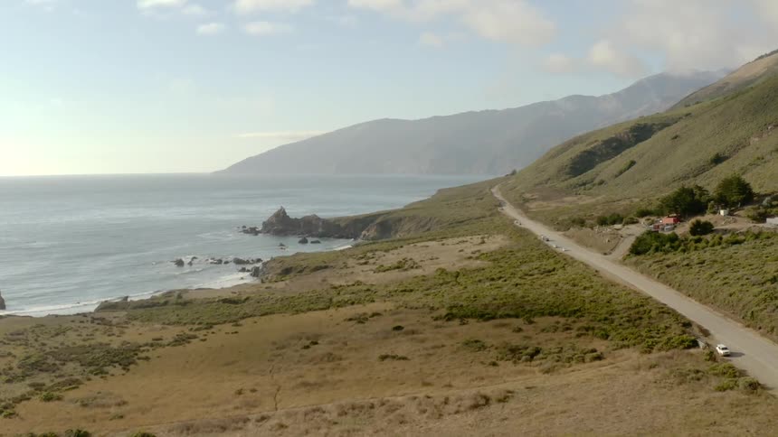 A winding road sits beside a coastal area