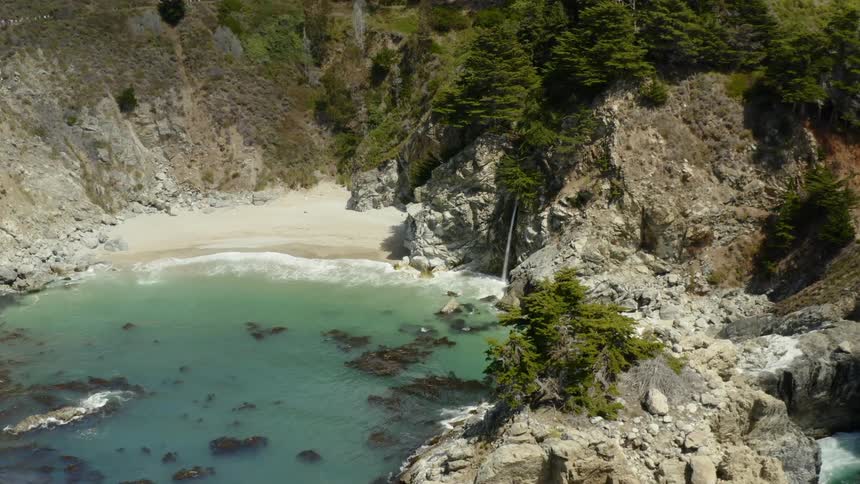 Waves crash on an isolate beach in the mountains