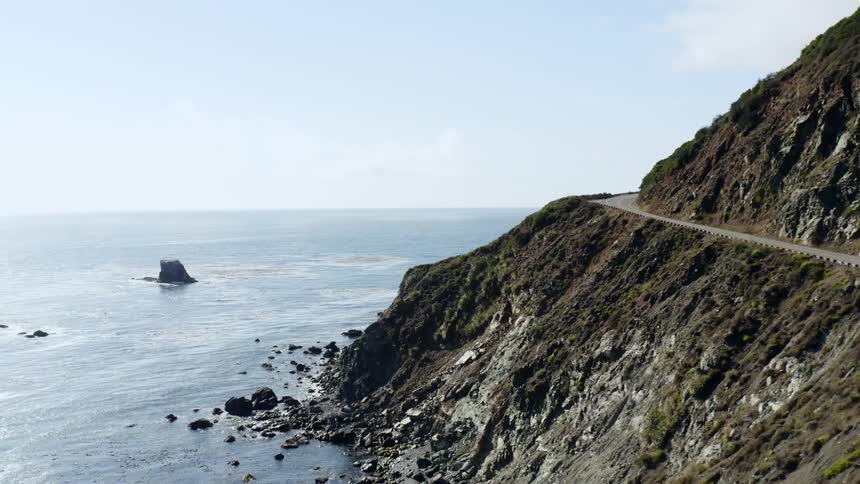 A roadway runs along a steep oceanside cliff