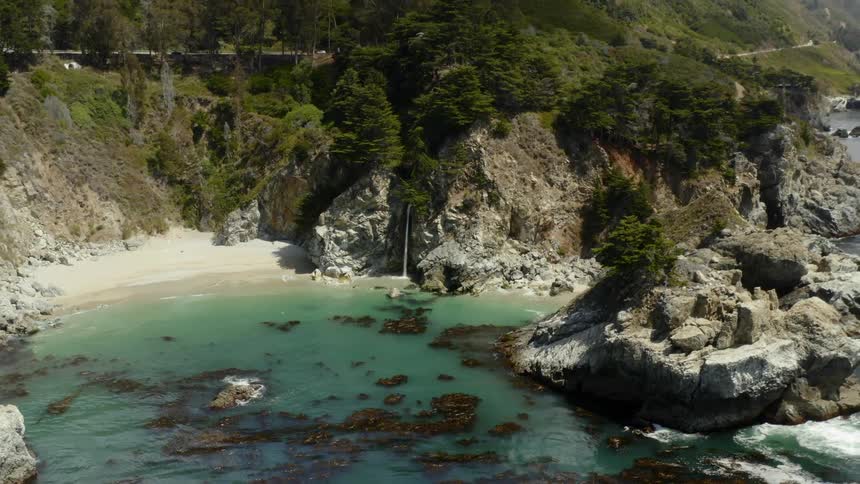 A rocky cove below a mountain road